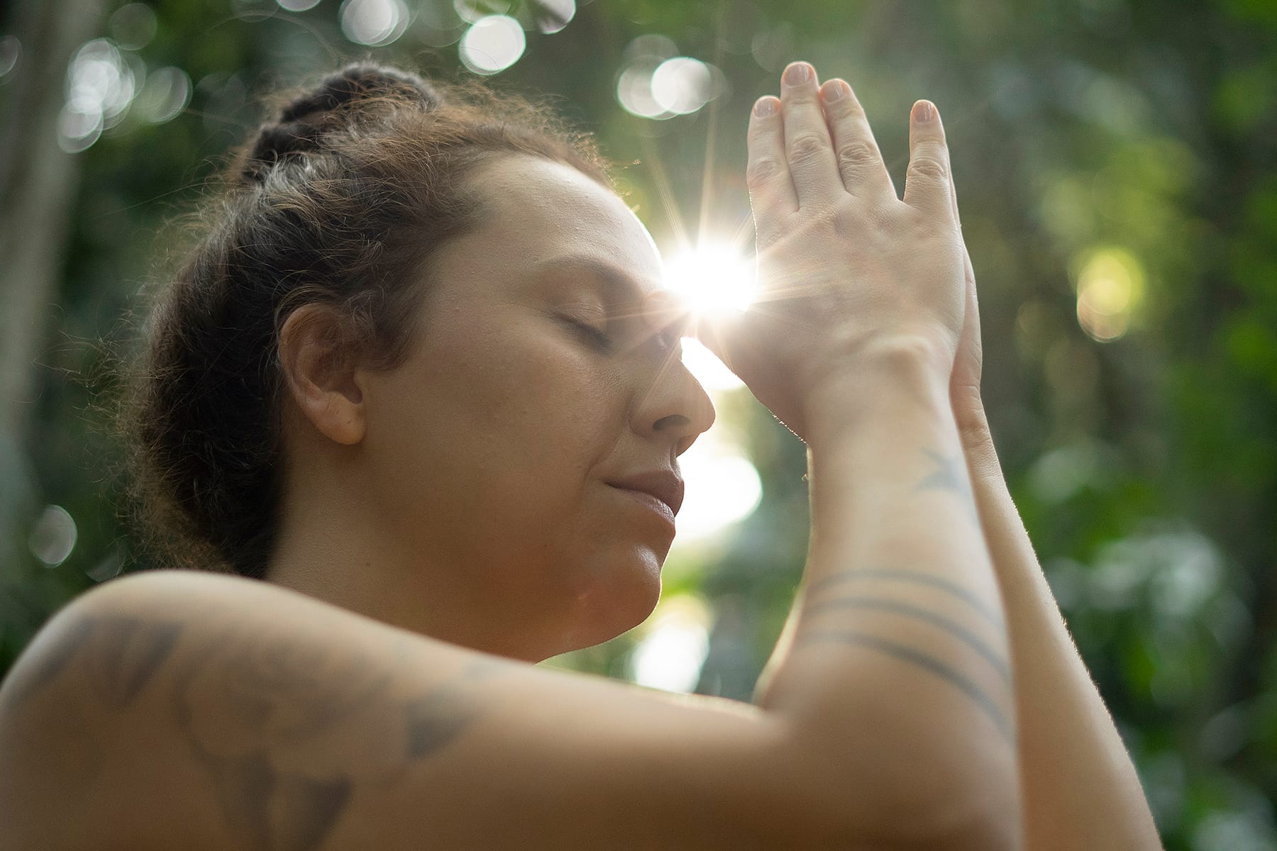Mulher com palmas unidas e polegares apoiados entre as sobrancelhas