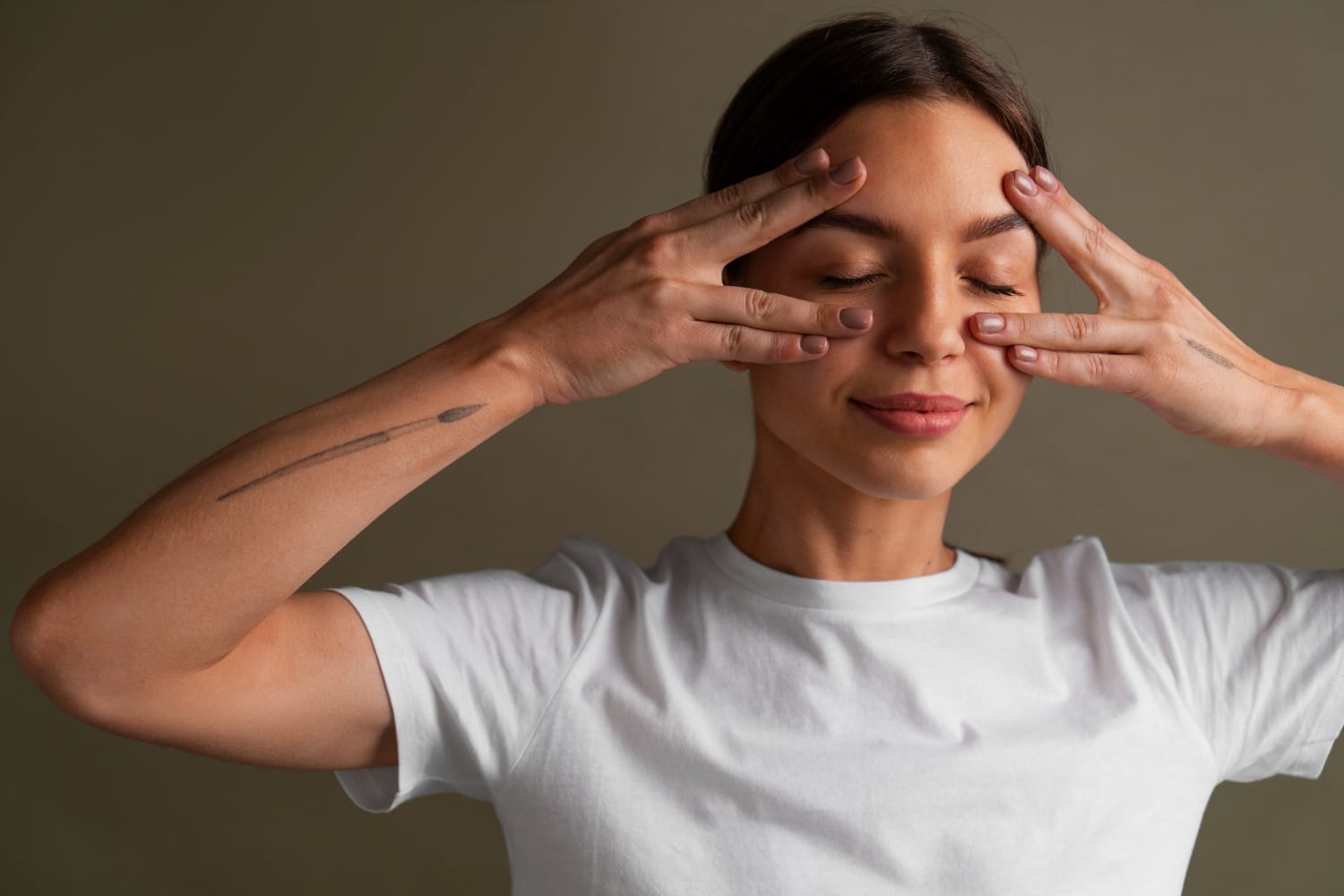 Mulher com dedos massageando a lateral dos olhos