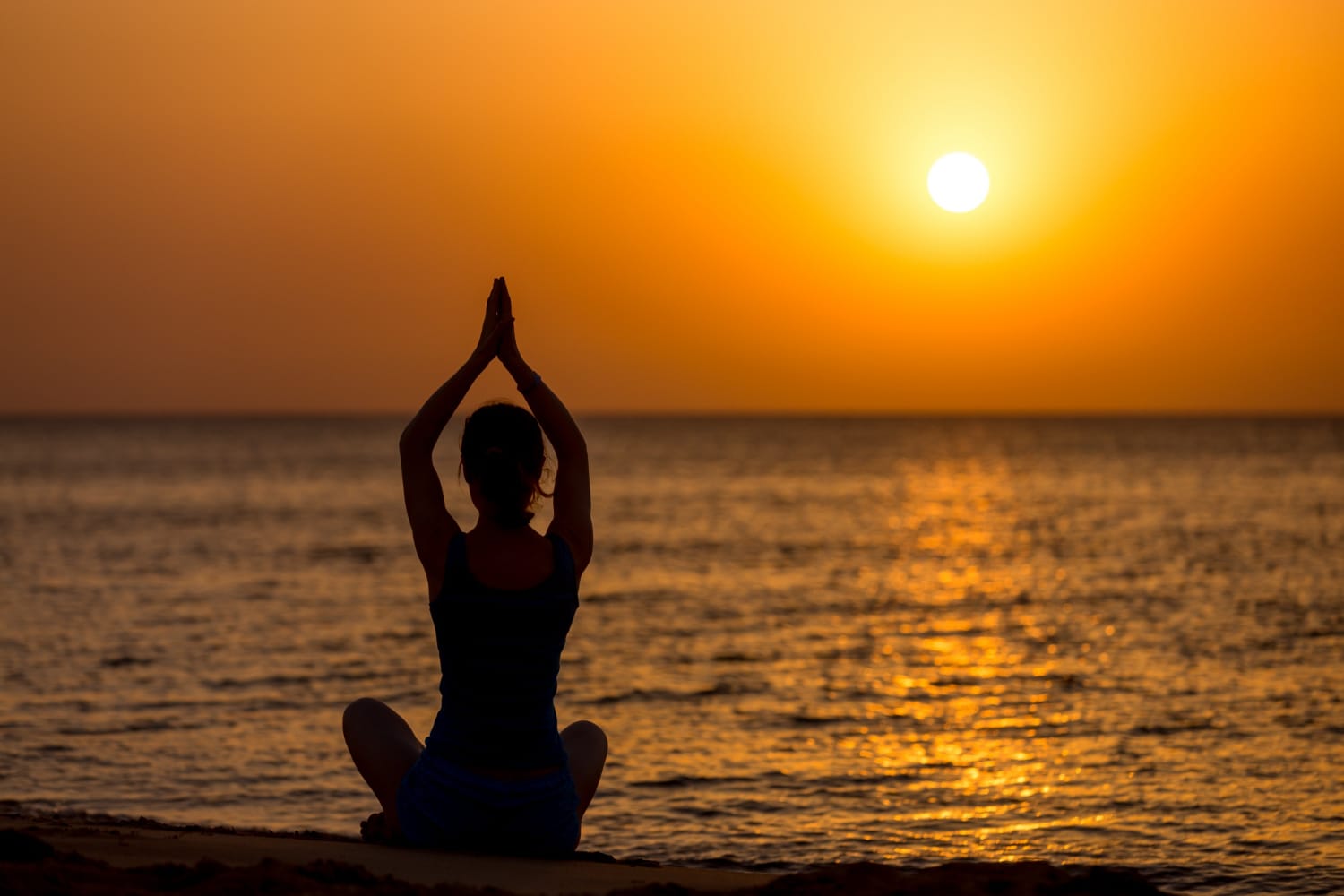 Mulher de costas sentada em postura meditativa